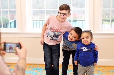 Kailyn Lowry's three sons posing for a photo as Lowry's hand is seen holding a camera.