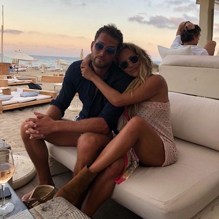 Caroline Flack embracing her boyfriend in a beachside restaurant seat.