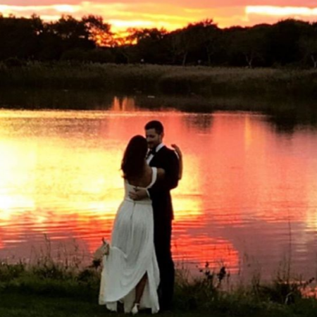 Sawyer Spielberg and Raye Levine at sunset beside a lake after their wedding.