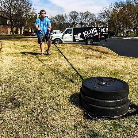 Luke Combs pushing three weights in his front yard.