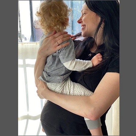 Laura Prepon holding Ella in her arms and revealing the growing baby bump.