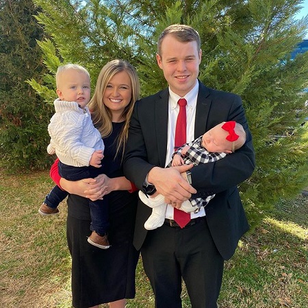Joseph and Kendra Duggar with their two kids, one in each of their arms.