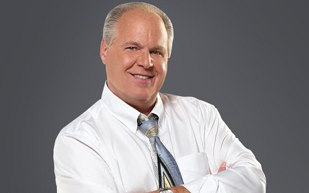 Rush Limbaugh in white shirt folding hands with a smile.