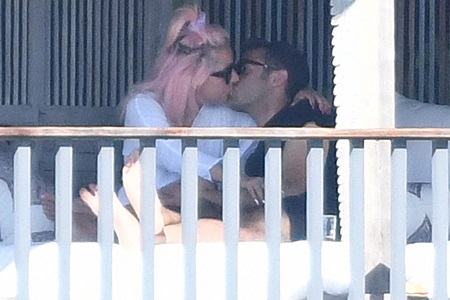 Lady Gaga kissing her new boyfriend, Michael Polansky, on the balcony of a Miami hotel.