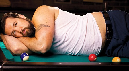 'Fat Mac' lying in a pool table with three balls in front of him.