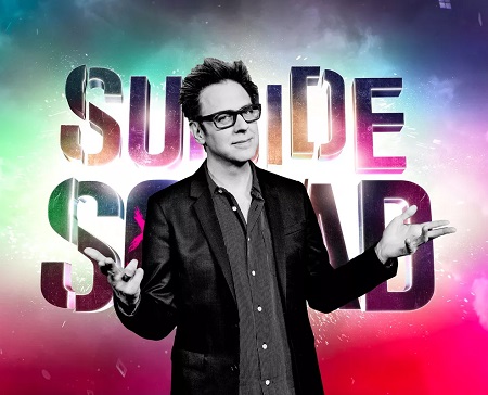 James Gunn in front of a 'Suicide Squad' poster.