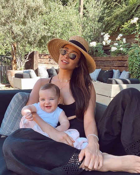 Shay Mitchell with her daughter Atlas in her lap.