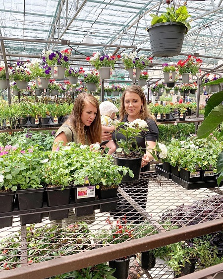 Jana Duggar and Anna Duggar looking at a flower pot in a nursery with Anna's baby.