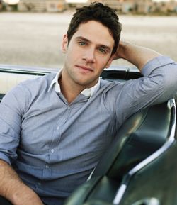 justin bartha posing in a light blue shirt